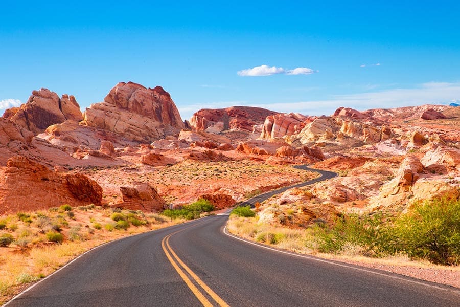 About Our Agency - Winding Road Through Dry, Rocky Nevada Landscape on a Sunny Day With a Bright Blue Sky Overhead