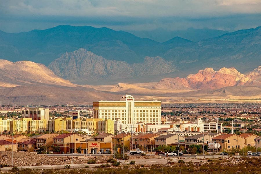 Henderson, NV Insurance - View of Hotels and Homes in Henderson, Nevada From a Distance, the Mountains Rising in the Background Under a Stormy Sky
