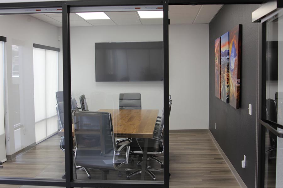 Office Tour - Conference Room Exterior Showing Large Conference Room Table, Chairs, Large Screen Television, Black Accent Wall and Southwest Artwork