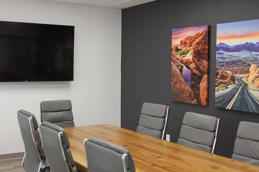 Office Tour - Conference Room Interior Showing Large Conference Room Table, Chairs, Large Screen Television, Black Accent Wall and Southwest Artwork